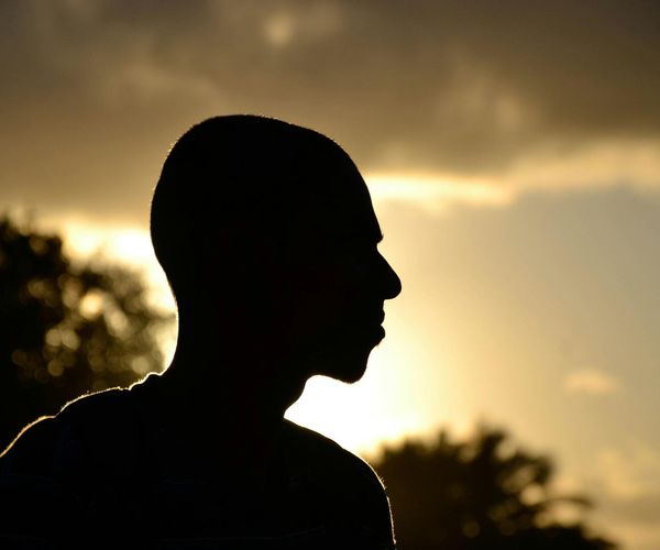 Silhouette of a person meditating against a calm background.